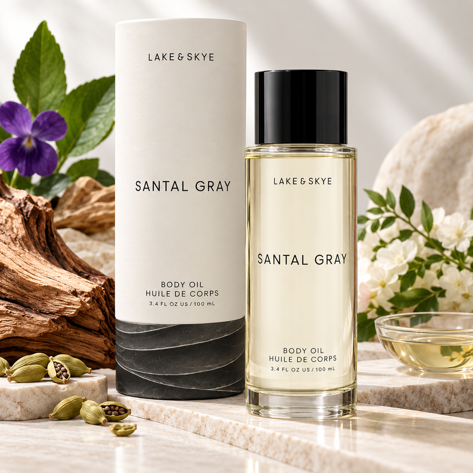 Lake & Skye Santal Gray Body Oil 3.4 oz (100 ml) luxury product presentation with sandalwood, violet flowers, cardamom, and elegant natural stone styling.