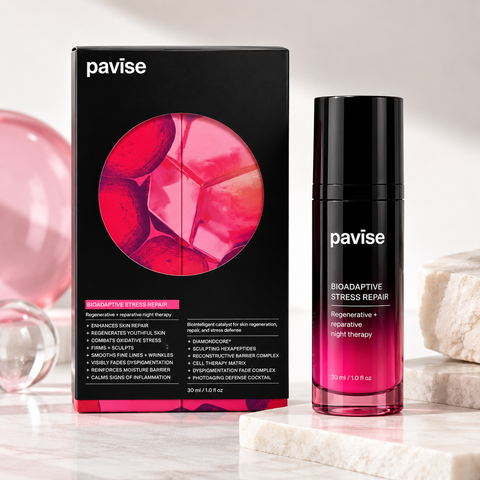 Pavise Bioadaptive Stress Repair 30ml nighttime facial treatment displayed with black and pink packaging on an elegant marble vanity with soft lighting, flowers, and skincare accessories.