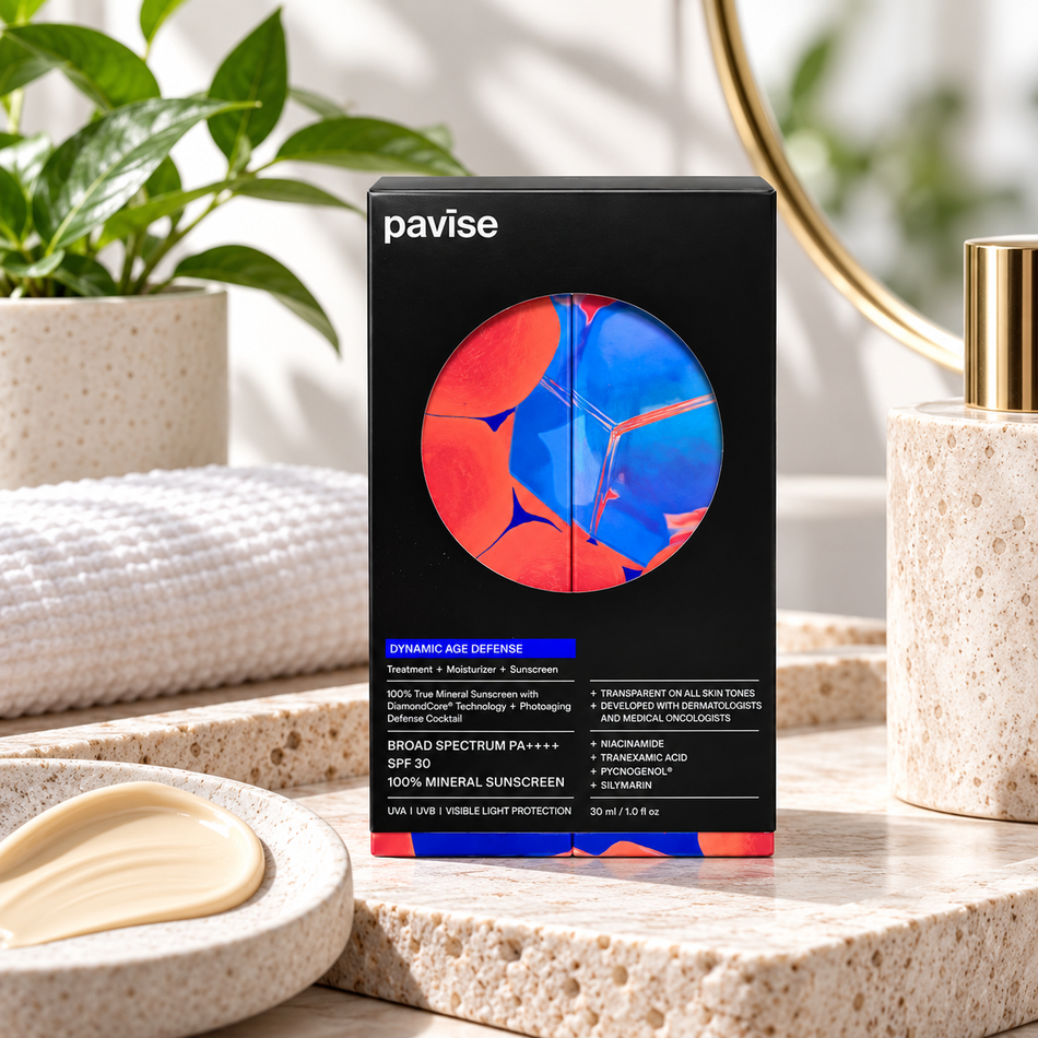 Pavise Dynamic Age Defense SPF 30 mineral sunscreen 30ml in black packaging displayed in a luxury skincare setting with a soft towel, natural greenery, and cream texture.